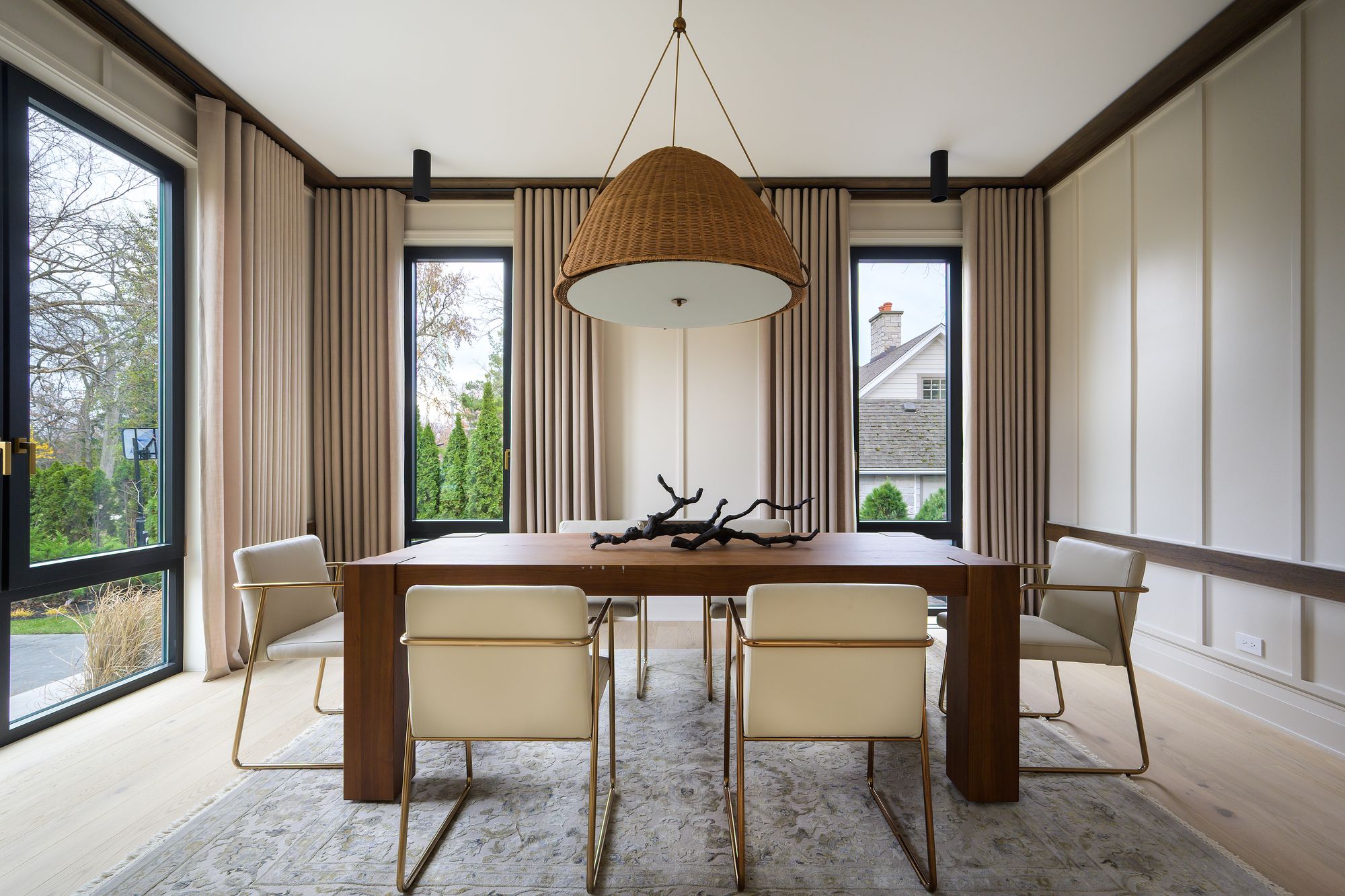 Dining room with a woven pendant over a walnut table